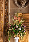 CHATSWORTH HOUSE, DERBYSHIRE: FLORABUNDANCE - THE CAREFREE MANS LANDING AT THE TOP OF THE GREAT STAIRCASE. BEAUTIFUL GARDEN-GROWN FLORAL DISPLAY IN CLASSIC URN ON PLINTH