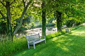GLYNDEBOURNE, EAST SUSSEX: LAWN WITH WOODEN BENCHES AND THE LAKE I N SUMMER. WATER, POOL, TRANQUIL, PEACEFUL, COUNTRY GARDEN, LANDSCAPE