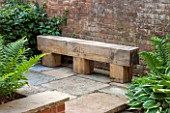 THE COACH HOUSE, SURREY: RUSTIC OAK BENCH WITH 2015 ENGRAVING ON PAVED AREA. STONE, WOOD, HANDMADE, TRADITIONAL, SEAT, SEATING.