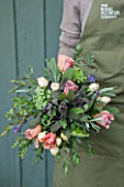 THE REAL FLOWER COMPANY:GIRL/WOMAN HOLDING BEAUTIFUL FLORAL POSY/ARRANGEMENT WITH ROSA CAFFE LATTE AND PAVLOVA. ALSO WITH PURPLE AND SILVER LAVENDER,MIXED SAGE AND SENECCIO