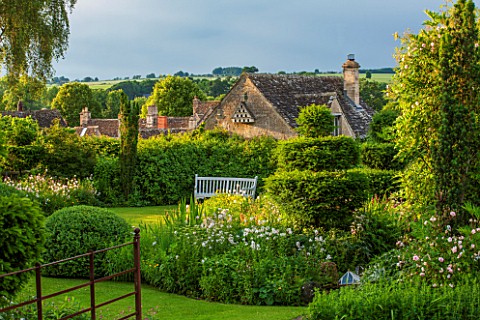 GREYHOUNDS_BURFORD_OXFORDSHIRE_VIEW_ACROSS_THE_GARDEN_TO_WOODEN_BENCH__THE_WINDRUSH_VALLEY_WITH_GARD