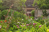 PYTTS PLACE, BURFORD: DAWN LIGHT ON VISTA FROM FOUNTAIN TO QUADRUPLE PERENNIAL BORDERS WITH FOXGLOVES, PEONIES, ALCHEMILLA MOLLIS, STACHYS BYZANTINA,AQUILEGIAS AND GRASSES