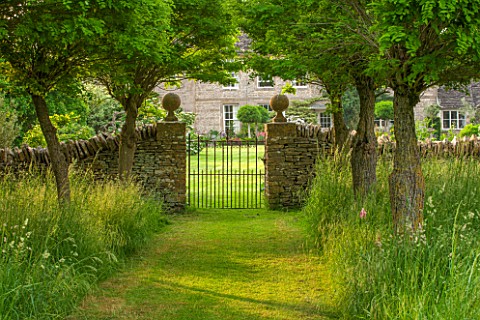 OXLEAZE_FARM_OXFORDSHIRE_GRASS_PATH_WITH_WILDFLOWERS_GRASSES_AND_VIEW_FROM_THE_ORCHARD_WITH_GATE_AND