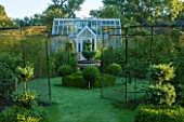 OXLEAZE FARM, OXFORDSHIRE: GARDEN WITH LAWN, GREENHOUSE, FRUIT CAGES AND CLIPPED BOX TOPIARY SHAPES.