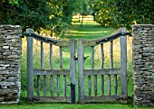 OXLEAZE FARM, OXFORDSHIRE: OAK CLEFT GATE WITH MOWN GRASS PATH BEYOND. VIEW, VISTA, ENTRANCE, SUNLIGHT