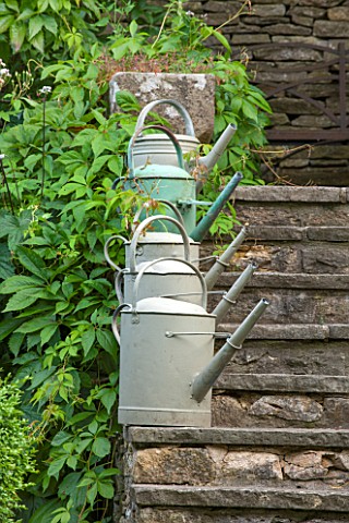 GREYHOUNDS_BURFORD_OXFORDSHIRE_METAL_WATERING_CANS_ON_THE_READING_ROOM_STEPS_REPETITION_DESIGN_FEATU
