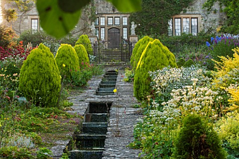 EASTLEACH_HOUSE_GLOUCESTERSHIRE_WEST_FACADE_OF_HOUSE_WITH_RILL_GREEN_BORDER__ALCHEMILLA_BRUNNERA_JAC