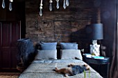 ABIGAIL AHERN HOUSE, LONDON: BEDROOM PAINTED IN CROSBY - MAUD THE DOG ON BED, PILLOWS, HAGUE WOODEN BEADED CHANDELIER, DARK, ROOM, INTERIOR, THROW