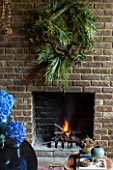 ABIGAIL AHERN HOUSE, LONDON: THE DINING ROOM - DARK, INTERIOR, WALL, DECORATION, GREEN WREATH, WALL, FIREPLACE, BLUE, HYDRANGEA