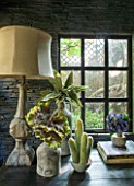 ABIGAIL AHERN HOUSE, LONDON: TOWN GARDEN. INTERIOR OF CABIN TYPE SHED. LAMP, FAUX PLANTS IN CONTAINERS, FAUX SLATED WALL, WINDOW