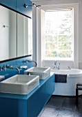 MORTON HALL, WORCESTERSHIRE:MASTER BATHROOM WITH WOODEN FITTED CUPBOARDS PAINTED WITH FB CHINESE BLUE,BATH & SINK BY DURAVIT,BATHTUB DESIGNED BY PHILIPPE STARK.TAPS BY DORNBRACHT