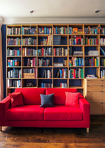 MORTON_HALL_WORCESTERSHIRE_READING_ROOM_WITH_OAK_BOOKSHELVES_AND_RED_SOFABED_JAMES