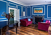 MORTON HALL, WORCESTERSHIRE: LIVING ROOM PAINTED AZURE BLUE. 18TH CENTURY FIRE SURROUND IN ITALIAN MARBLE. STEINWAY BABY GRAND PIANO, MAGENTA VELVET SOFAS BY DONGHIA