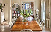 THE COACH HOUSE,SURREY:BREAKFAST ROOM WITH LARGE TABLE & CHAIRS, MANDARIN STONE FLOOR, BOOKCASE, DEMI LUNE TABLES. FRENCH COUNTRY STYLE, NEUTRAL DECOR