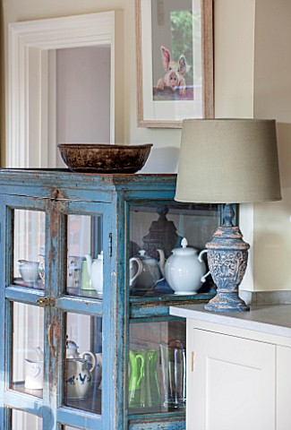 THE_COACH_HOUSESURREY_THE_BREAKFAST_ROOM_WITH_DISTRESSED_BLUE_CABINET_BOWL_AND_LAMP_FROM_PETWORTH_AN