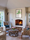 THE COACH HOUSE,SURREY:THE BREAKFAST ROOM WITH ROARING LOG FIRE, COMFY ARMCHAIRS BY HUDSON HOMES & INTERIORS AND COFFEE TABLE BY OKA. COSY, RELAXING