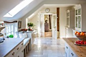 THE COACH HOUSE,SURREY: COUNTRY KITCHEN BY PLAIN ENGLISH, WITH BLUE LIMESTONE WORKTOPS AND ISLAND.NEUTRAL DECOR,LIGHT,AIRY, TUMBLED MARBLE FLOOR, WINDOW SEAT.
