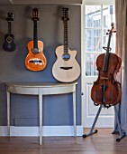 THE COACH HOUSE,SURREY: DEMI LUNE TABLE FROM CHELSEA TEXTILES WITH MUSICAL INSTRUMENTS: ACOUSTIC GUITARS AND CELLO