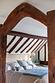 THE COACH HOUSE,SURREY: BEDROOM WITH DETAIL OF WOODEN BEAMS. CUSHIONS AND BED COVER BY HUDSON HOMES & INTERIORS. SIDE TABLE BY OKA