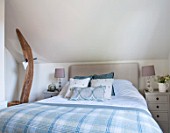 THE COACH HOUSE,SURREY: GUEST BEDROOM - BLANKET FROM NEPTUNE, CUSHIONS FROM HUDSON HOMES & INTERIORS. NEUTRAL DECOR. OAK BEAM SUPPORT WITH HANGING HEART.