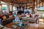 THE COACH HOUSE,SURREY: FAMILY ROOM WITH EXPOSED OAK BEAMS AND PIANO. SOFAS, LARGE GLASS COFFEE TABLE, BEAUTIFUL RUG ON WOODEN FLOOR. RELAX, READING ROOM, MUSIC ROOM.