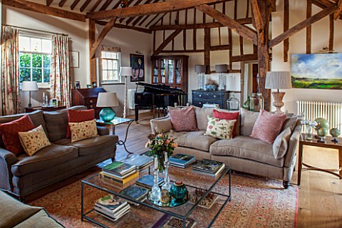 THE_COACH_HOUSESURREY_FAMILY_ROOM_WITH_EXPOSED_OAK_BEAMS_AND_PIANO_SOFAS_LARGE_GLASS_COFFEE_TABLE_BE