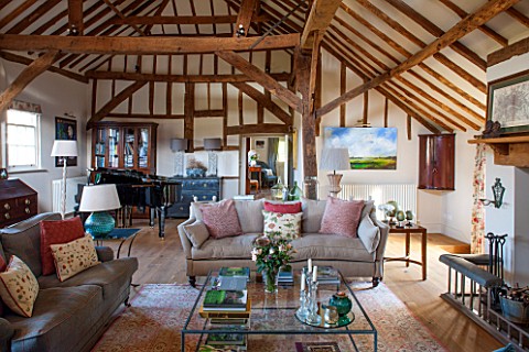 THE_COACH_HOUSESURREY_FAMILY_ROOM_WITH_EXPOSED_OAK_BEAMS_AND_PIANO_SOFAS_LARGE_GLASS_COFFEE_TABLE_BE