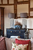 THE COACH HOUSE,SURREY: FAMILY ROOM WITH CHEST OF DRAWERS FROM THREE GATES GALLERY, LAMPS BY OKA. CUSHIONS ON SOFA BY CHELSEA TEXTILES.