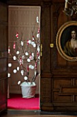 BURTON AGNES HALL, EAST YORKSHIRE: CHRISTMAS - THE JUSTICES ROOM - A SYCAMORE BRANCH DECORATED WITH PAPER SNOWFLAKES AND HAND KNITTED STOCKINGS