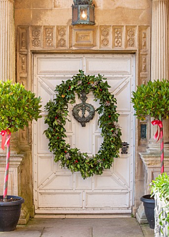 BURTON_AGNES_HALL_EAST_YORKSHIRE_CHRISTMAS__WHITE_FRONT_DOORWAY_WITH_BAY_TREES_IN_BLACK_CONTAINERS_H