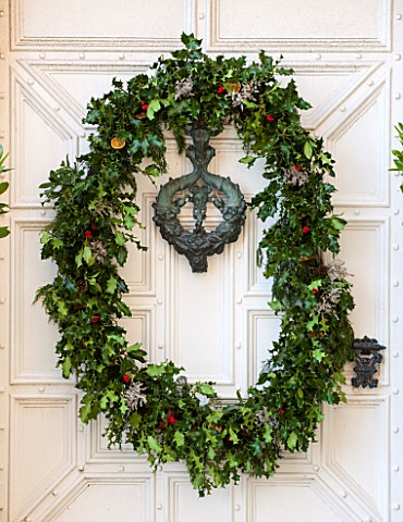 BURTON_AGNES_HALL_EAST_YORKSHIRE_CHRISTMAS__WHITE_FRONT_DOORWAY_WITH_HOLLY_AND_BERRY_WREATH_MADE_BY_