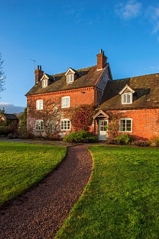 THE_FREETH_HEREFORDSHIRE_15TH_CENTURY_HOUSE_WITH_BRICK_FACADE_PATH_LAWN_GRASS_SUNSET_EVENING_LIGHT