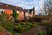 THE FREETH, HEREFORDSHIRE: 15TH CENTURY HOUSE WITH BRICK FACADE, PATH, LAWN, GRASS, SUNSET, EVENING, LIGHT. BOX PARTERRE DESIGNED BY ROBERT MYERS. GARDEN