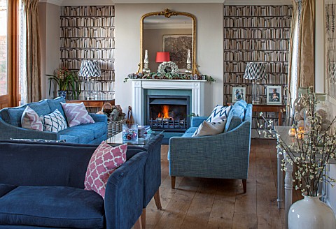THE_FREETH_HEREFORDSHIRE_THE_SITTING_ROOM_FIRE_FIREPLACE_BOOKCASE_WALL_PAPER_TEAL_SOFAS_WOOD_FLOOR_G