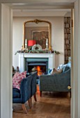 THE FREETH, HEREFORDSHIRE: THE SITTING ROOM. FIRE, FIREPLACE, BOOKCASE WALL PAPER, TEAL SOFAS, WOOD FLOOR, GILT MIRROR, LIVING, ROOM