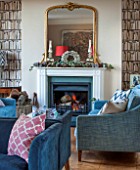 THE FREETH, HEREFORDSHIRE: THE SITTING ROOM. FIRE, FIREPLACE, BOOKCASE WALL PAPER, TEAL SOFAS, WOOD FLOOR, GLASS AND STONE PEDESTAL TABLE, GILT MIRROR, LIVING, ROOM