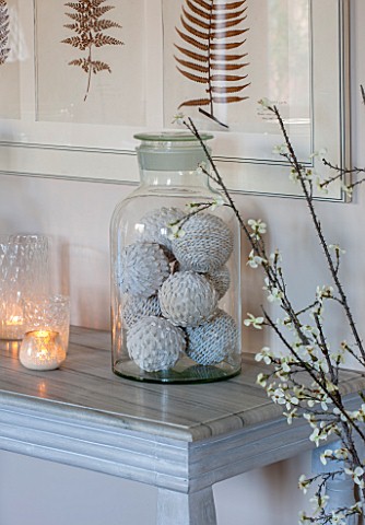 THE_FREETH_HEREFORDSHIRE_THE_SITTING_ROOM_LARGE_GLASS_JAR_ON_TABLE_WITH_DECORATIVE_WOVEN_BALLS_FERN_