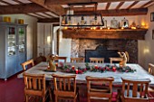 THE FREETH, HEREFORDSHIRE: KITCHEN, DINER - WOODEN FARMHOUSE TABLE, SCHOOL, CHURCH CHAIRS, GOLDEN ANTIQUE ANGEL CANDLE HOLDERS, FIREPLACE, RED FLOORING, BLUE GLASS CUPBOARD