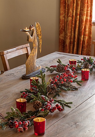 THE_FREETH_HEREFORDSHIRE_KITCHEN_DINER__WOODEN_TABLE_WITH_BERRY_DECORATION_CANDLES_GOLDEN_ANGEL_CAND