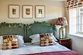 THE FREETH, HEREFORDSHIRE: GREEN AND RUBY BEDROOM. RATAN BEDHEADS, SHOE PRINT CUSHIONS, THROW, TULIP PRINT BLIND, LAMP AND SHADE