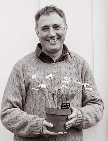 HILL_CLOSE_GARDENS_WARWICK_BLACK_AND_WHITE_IMAGE_OF_HEAD_GARDENER_GARY_LEAVER_HOLDING_SNOWDROPS_IN_T