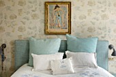LONDON HOUSE DESIGNED BY JULIE SIMONSEN. BLUE BEDROOM WITH ANTIQUE PAINTING ON WALL. WALLPAPER BY COLEFAX & FOWLER