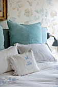 LONDON HOUSE DESIGNED BY JULIE SIMONSEN. BLUE BEDROOM WITH DETAIL OF CUSHIONS AND BEDLINEN. WALLPAPER BY COLEFAX & FOWLER