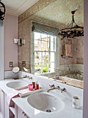 LONDON HOUSE DESIGNED BY JULIE SIMONSEN.  TWIN BASINS IN PINK BATHROOM WITH MARBLE SURROUND. FAUX VERRE EGLOMISE MIRROR.