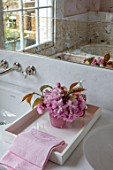 LONDON HOUSE DESIGNED BY JULIE SIMONSEN. PINK BATHROOM. CHERRY BLOSSOM ON TRAY WITH FAKE VERRE EGLOMISE MIRROR AND MARBLE SURROUND