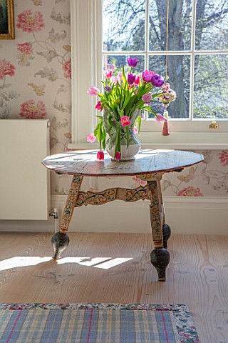 LONDON_HOUSE_DESIGNED_BY_JULIE_SIMONSEN_TABLE_WITH_VASE_OF_TULIPS_IN_PINK_GUEST_ROOM_IS_A_HANDPAINTE