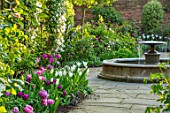 MORTON HALL, WORCESTERSHIRE: SPRING, APRIL, PATH WITH TULIPS, WATER FOUNTAIN, ARCH WITH CLEMATIS. CLASSIC, FORMAL, ENGLISH, COUNTRY, GARDEN