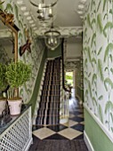 BUTTER WAKEFIELD HOUSE, LONDON. THE HALLWAY. ENTRANCE WITH PALM FROND DECORATED WALLPAPER AND STRIPED CARPET ON STAIRS. MIRROR