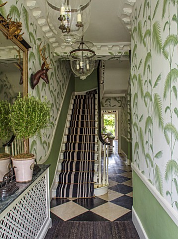 BUTTER_WAKEFIELD_HOUSE_LONDON_THE_HALLWAY_ENTRANCE_WITH_PALM_FROND_DECORATED_WALLPAPER_AND_STRIPED_C