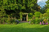 MORTON HALL, WORCESTERSHIRE: SOUTH GARDEN,  SUMMER. LAWN, PERGOLA, WOODEN, BEDS, BORDERS, HERBACEOUS, EVENING LIGHT, FORMAL, COUNTRY, GARDEN, ENGLISH, CLASSIC